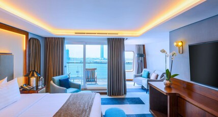 Queen Elizabeth 2 Room Type - Duplex Suite with 1 King size bed and separate living room area with a sofabed
