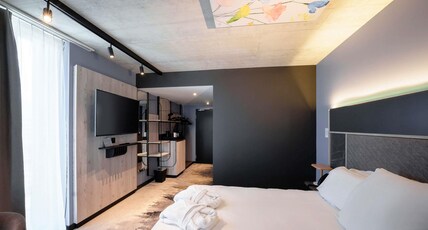 Mercure Hotel Del Room Type - Privilege Room with a king-size bed and armchairs
