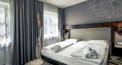 Mercure Hotel Muenchen am Olympiapark Room Type - Privilege Room with a sofa or armchair and the new Mercure Great Bed
