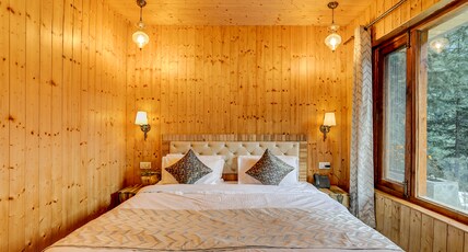 Vedants Room Type - Super Deluxe Room with wooden interiors, mountain view, open sitting area, and conifer covered surro